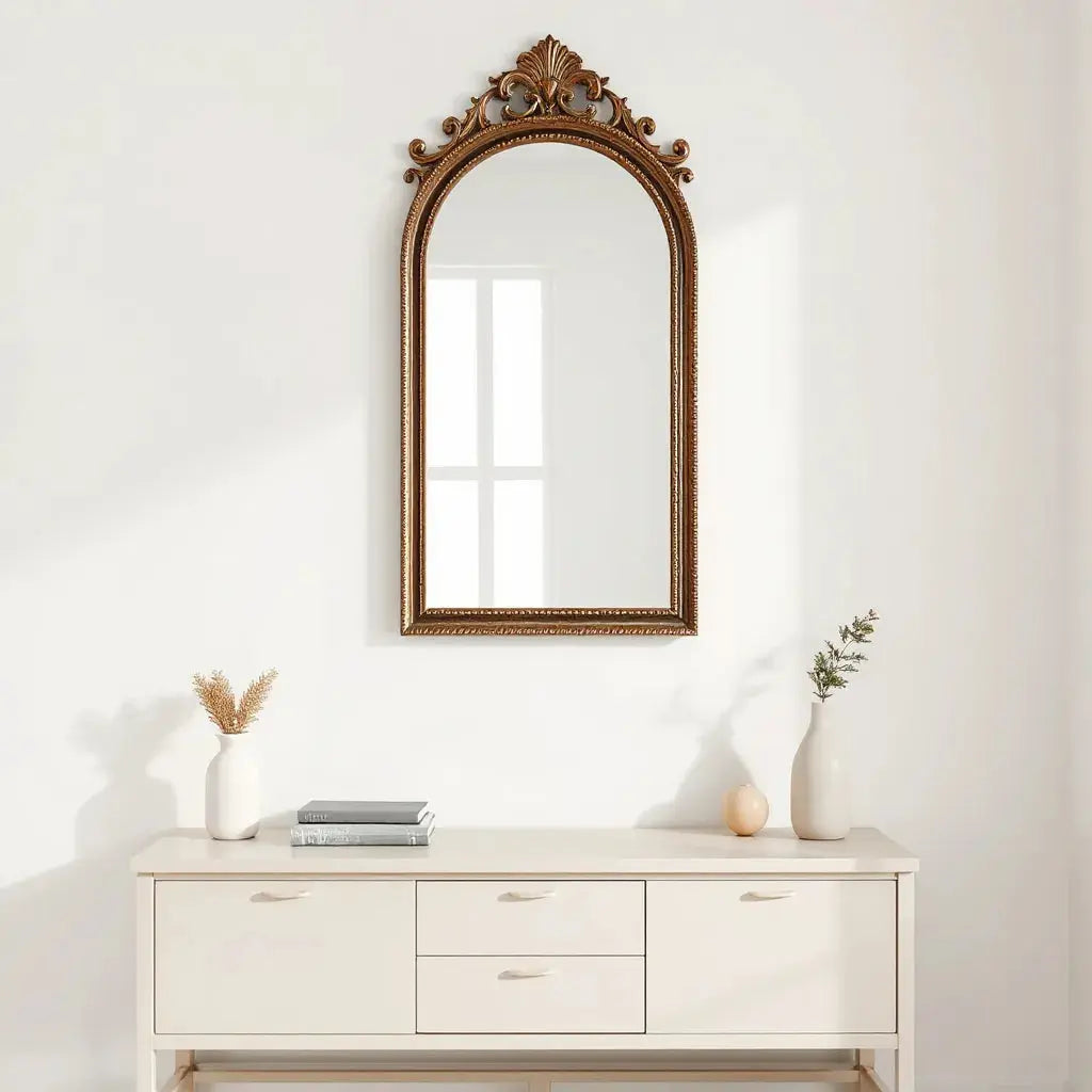 Ornate manga-inspired mirror on a light wall above a simple console table with decor