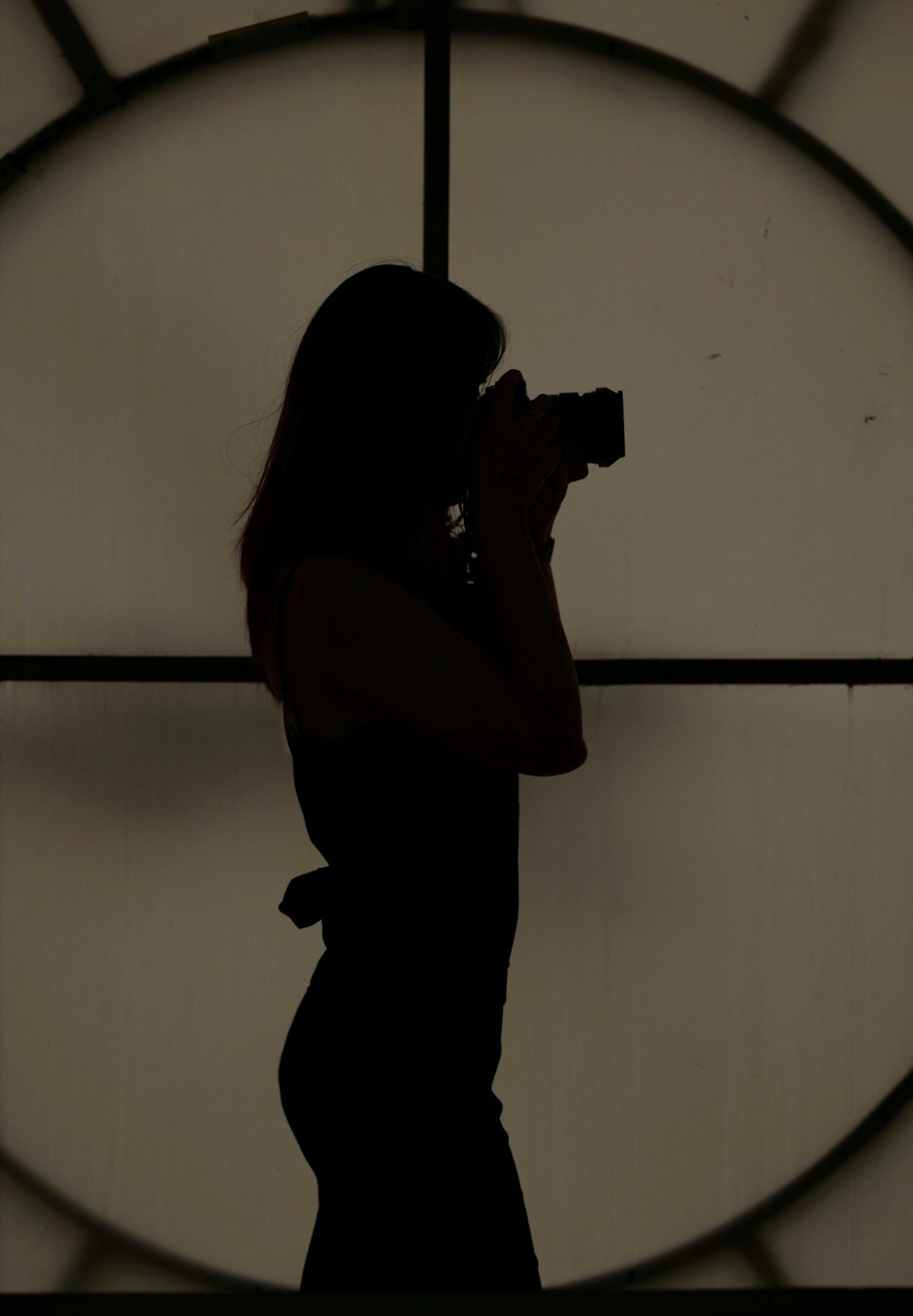 silhouette of woman using camera
