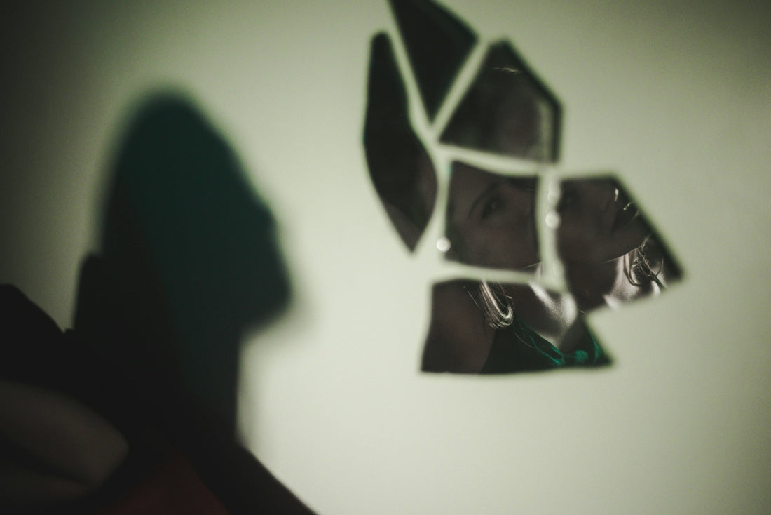 broken glass mirror with woman's reflection