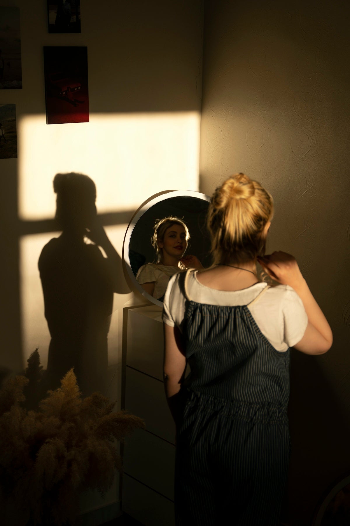 a woman standing in front of a mirror in a room