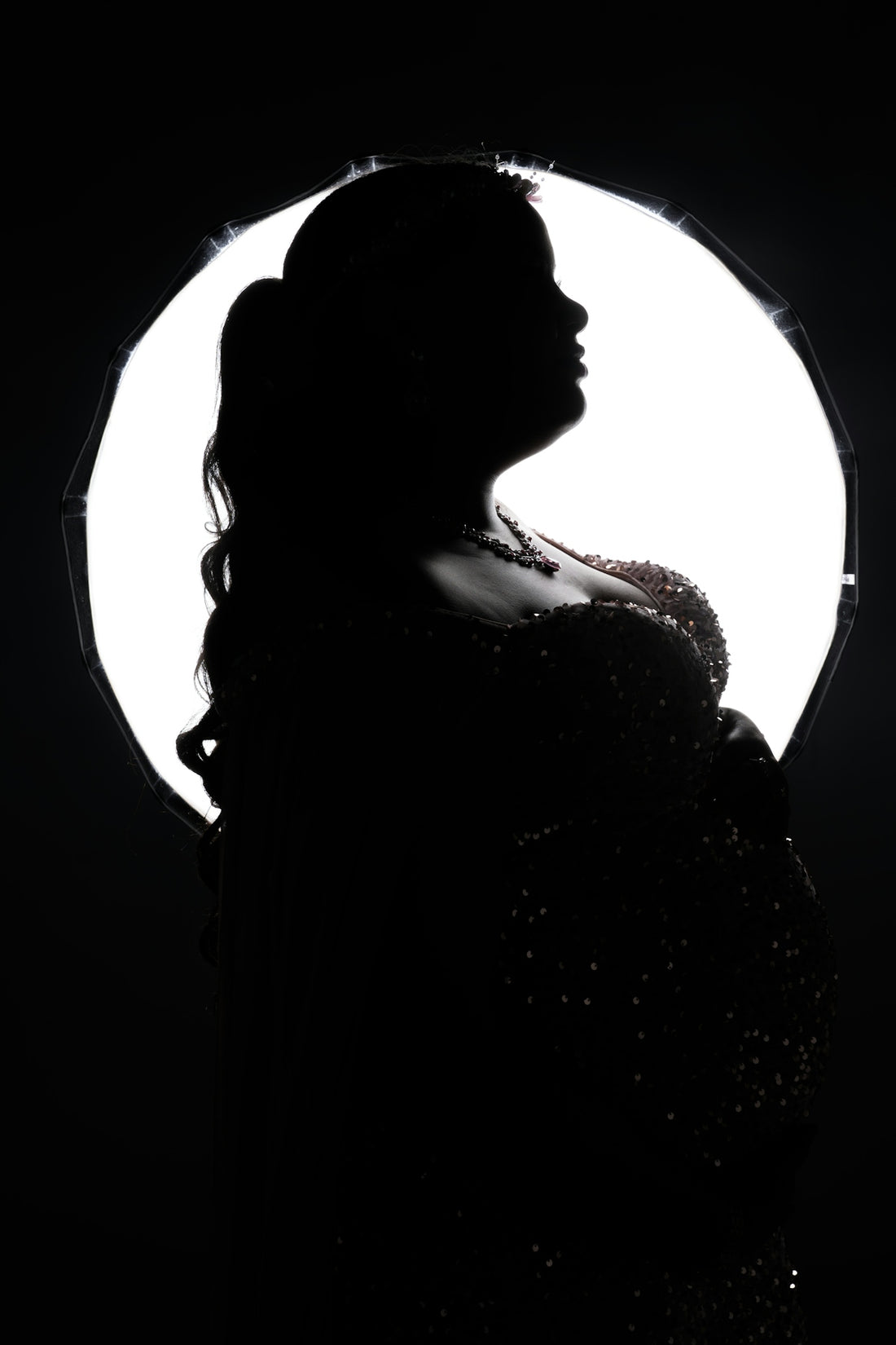 A silhouette of a woman standing in front of a light