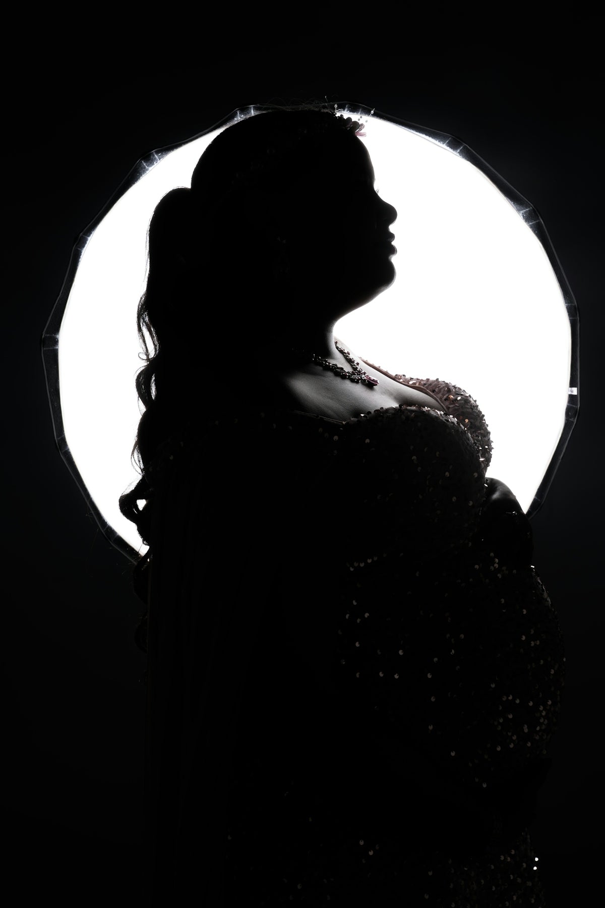 A silhouette of a woman standing in front of a light
