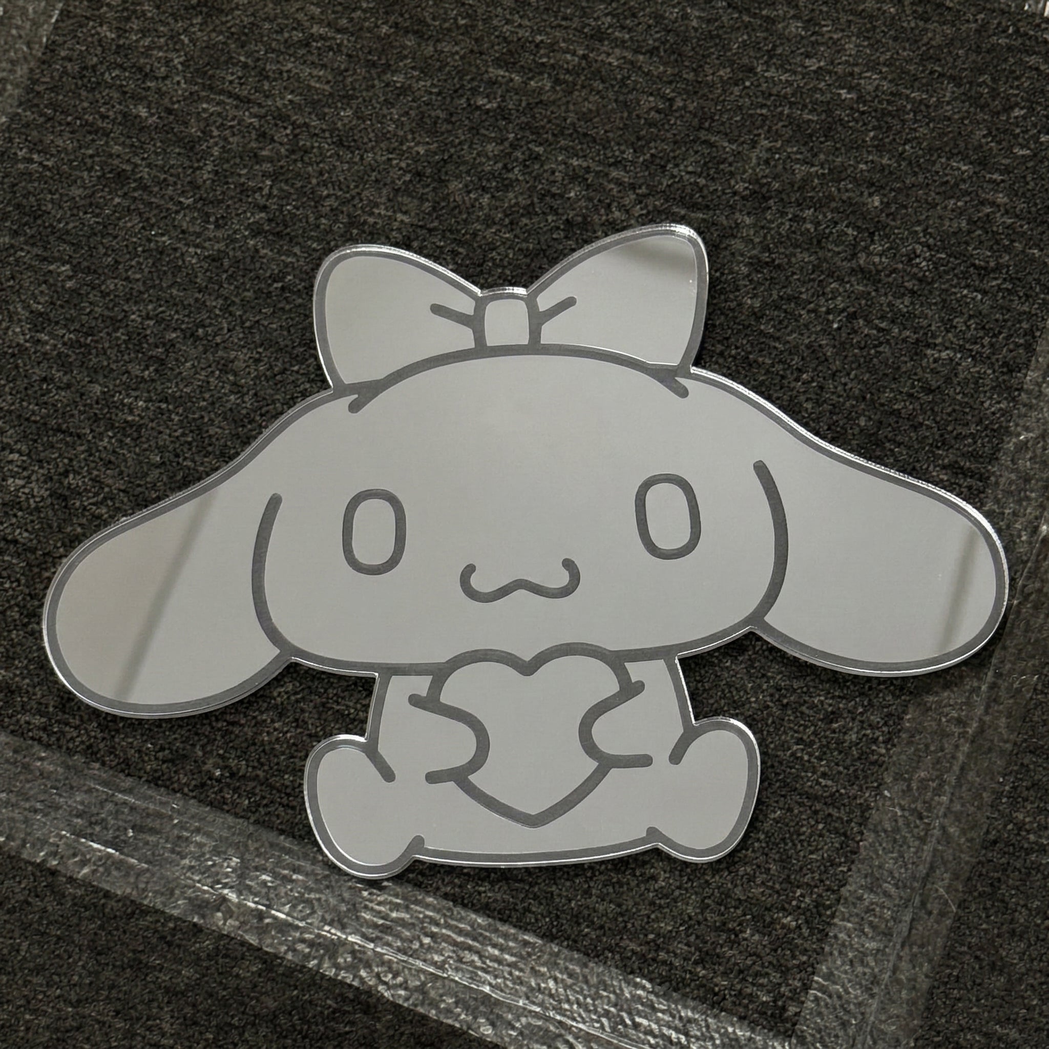 Bunny-shaped acrylic mirror displayed outdoors with potted plants