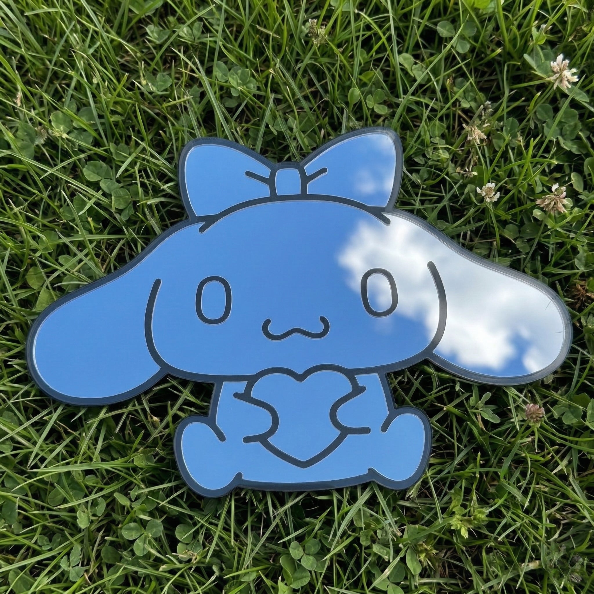 Bunny-shaped acrylic mirror displayed outdoors with potted plants